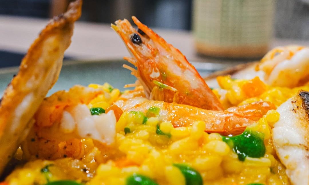 Prato de arroz amarelo com camarão e legumes verdes